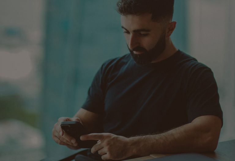 Man using iphone with his left arm propped up on the table. Photo by Hoi An and Da Nang Photographer on Unsplash
